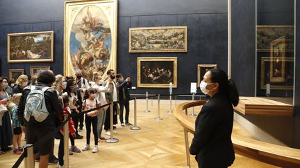 Des visiteurs masqués au musée du Louvre, à Paris, le 6 juillet 2020. (FRANCOIS GUILLOT / AFP)