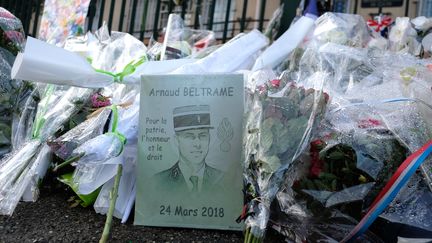 Des fleurs, des bougies et des dessins ont été déposés devant la gendarmerie de Carcassonne, en hommage à Arnaud Beltrame, juste après sa mort. (ERIC CABANIS / AFP)