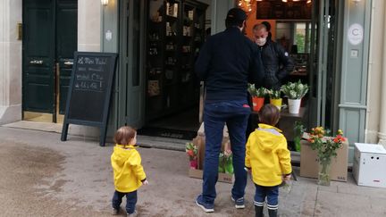 Nasser vend du muguet devant une fromagerie, à Levallois-Perret (Hauts-de-Seine), le 1er mai 2020. (VICTOR VASSEUR / RADIOFRANCE)