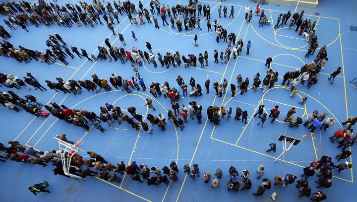 Des Barcelonais font la queue dans un gymnase pour participer &agrave; la consultation sur l'avenir de la Catalogne.&nbsp; (ALBERT GEA / REUTERS)