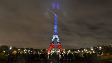 La tour Eiffel, à Paris, illuminée aux couleurs du drapeau français en hommage aux victimes des attentats de la capitale française, le 17 novembre 2015. (MUSTAFA YALCIN / ANADOLU AGENCY / AFP)