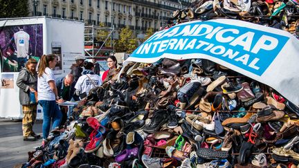 Comme chaque année, l'ONG Handicap International réalise une pyramide de chaussures pour dénoncer les mines dans le monde, comme ici en 2017.&nbsp; (STR / AFP)