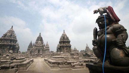 Un employ&eacute; nettoie les statues du temple Sewu couvertes des cendres du mont Kelud sur l'&icirc;le de Java (Indon&eacute;sie), le 18 f&eacute;vrier 2014. (MAXPPP)