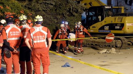 Des secouristes de la Croix-Rouge italienne transporte le corps d'une victime du s&eacute;isme le 26 ao&ucirc;t 2016 &agrave; Amatrice (Italie). (ANDREAS SOLARO / AFP)