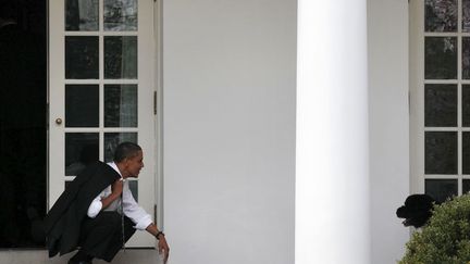 Le pr&eacute;sident am&eacute;ricain Barack Obama appelle son chien Bo sur le perron du bureau ovale &agrave; la Maison Blanche, Washington (Etats-Unis), le 15 mars 2012. (LARRY DOWNING / REUTERS)