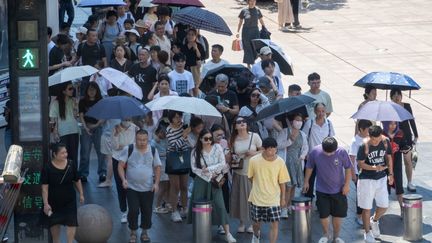 A Shanghai, en Chine, des personnes se protègent du soleil avec des parapluies, le 6 août 2024, en pleine canicule. (CFOTO / NURPHOTO / AFP)