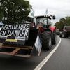 Un manifestant conduit un tracteur avec une pancarte "Agriculture en danger" le 19 juillet 2015, pr&egrave;s de Caen. (CHARLY TRIBALLEAU / AFP)