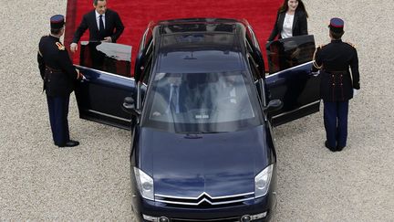 Le couple Sarkozy monte &agrave; bord d'une Citro&euml;n pour quitter le palais de l'Elys&eacute;e. (PATRICK KOVARIK / AFP)