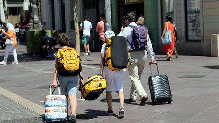 Des touristes avec des valises dans la rue (photo d'illustration) (VALLAURI NICOLAS / MAXPPP)