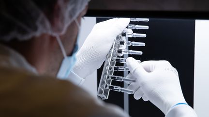 Un technicien inspecte des seringues dans un laboratoire de Sanofi à Val-de-Reuil, le 10 juillet 2020 (photo d'illustration). (JOEL SAGET / AFP)