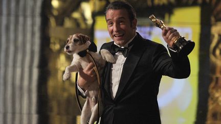 Jean Dujardin pose avec son Oscar, le chie Uggie dans les bras, le 26 f&eacute;vrier 2012 &agrave; Los Angeles (Etats-Unis). (ROBYN BECK / AFP)