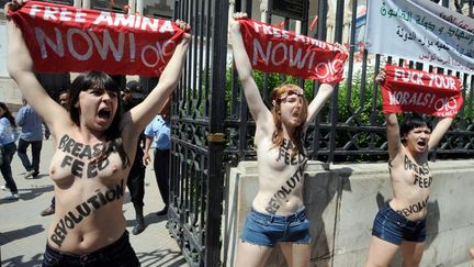 Les trois Femen lors de leur action seins nus le 29 mai 2013 devant le palais de justice de Tunis, en soutien &agrave; la Femen&nbsp;Amina Sbou&iuml;. (FETHI BELAID / AFP)