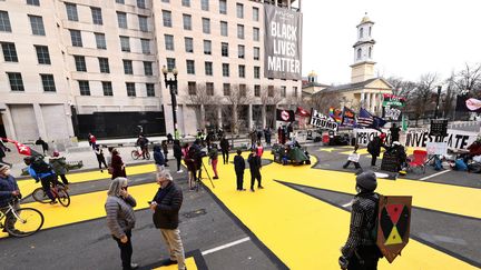 Malgré les mesures de sécurité, journalistes et passants continuent de se rassembler sur la "Black Lives Matter Plaza", qui fait face à la Maison Blanche, le 16 janvier 2021. (MICHAEL M. SANTIAGO / GETTY IMAGES NORTH AMERICA / AFP)