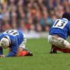 Les joueurs du XV de France, Thomas Castaignède et Pascal Giordani, récupèrent sur la pelouse de Twickenham (Londres), le 20 mars 1999. (PATRICK KOVARIK / AFP)