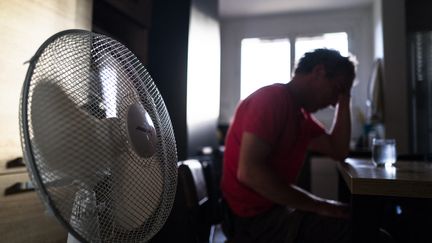 Un homme s'hydrate à côté d'un ventilateur, à Toulouse (Haute-Garonne), le 17 juillet 2023. (FREDERIC SCHEIBER / HANS LUCAS / AFP)