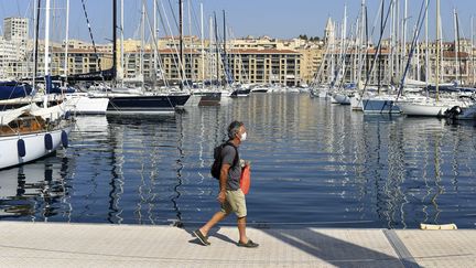 Un homme marche sur un quai du Vieux-Port, à Marseille, le 14 septembre 2020. (NICOLAS TUCAT / AFP)