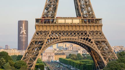 La tour Eiffel à Paris, avec la tour Montparnasse au second plan, ornée du logo de candidature de la capitale&nbsp;en vue d'accueillir les JO 2024. (GARDEL BERTRAND / AFP)