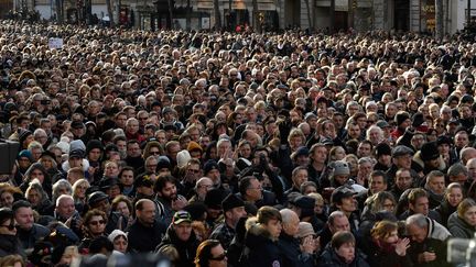 Le public nombreux a assisté à la cérémonie funéraire sur un écran géant installé devant l'église. (BERTRAND GUAY / AFP)