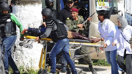 Des policiers et ambulanciers &eacute;vacuent une victime de l'attentat perp&eacute;tr&eacute; &agrave; Tunis, le 18 mars 2015. (HASSENE DRIDI / AP / SIPA)