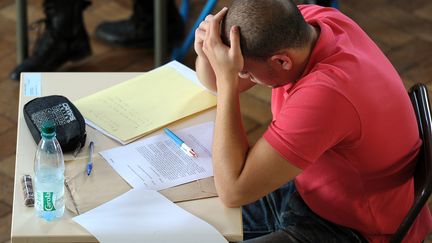 Un candidat se prend la t&ecirc;te entre les mains lors de l'&eacute;preuve de philosophie du baccalaur&eacute;at, le 18 juin 2012 au lyc&eacute;e Pasteur de Strasbourg (Bas-Rhin). (FREDERICK FLORIN / AFP)