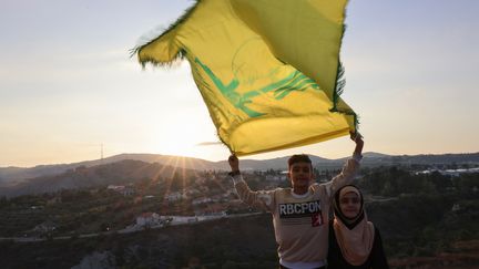 Des enfants libanais avec un drapeau du Hezbollah, à la frontière israélo-libanaise, le 12 octobre 2023 (JOSEPH EID / AFP)