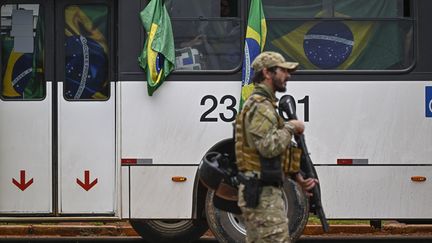 Des partisans de l'ex-président brésilien Jair Bolsonaro sont emmenés en bus par les forces de l'ordre, le 9 janvier 2023, au lendemain des actes de vandalisme lors des invasions des lieux de pouvoir à Brasilia. (MAURO PIMENTEL / AFP)