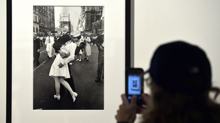 Une personne prend en photo le célèbre cliché du baiser pris par le photographe&nbsp;Alfred Eisenstaedt&nbsp;à Times Square en 1945 après l'annonce de la fin de la Second Guerre mondiale. (GABRIEL BOUYS / AFP)