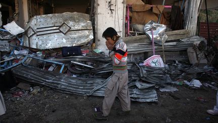 Un gar&ccedil;on traverse le lieu de l'explosion d'un camion citerne,&nbsp;&agrave; Hazara Town, dans la banlieue de Quetta, au Pakistan, le 17 f&eacute;vrier 2013. (NASEER AHMED / REUTERS)