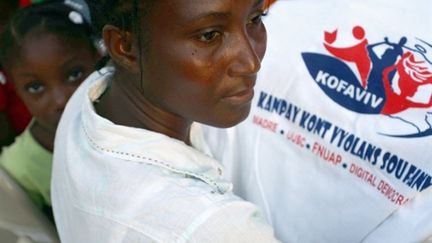 Une Haïtienne tient un tee-shirt avec le logo de Kossavi, association pour la défense des femmes dans les camps. (AFP)