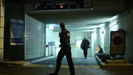 Un policier marche devant l'entr&eacute;e du parking o&ugrave; un homme a &eacute;t&eacute; arr&ecirc;t&eacute; dans l'enqu&ecirc;te sur le tireur parisien, &agrave; Bois-Colombes (Hauts-de-Seine), le 20 novembre 2013. (KENZO TRIBOUILLARD / AFP)