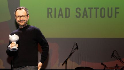 L'auteur de bande dessinée et réalisateur Riad Sattouf, Grand Prix de la ville d'Angoulême 2023 sur la scène de la cérémonie d'ouverture de la 50e édition du Festival international de la bande dessinée d'Angoulême, le 25 janvier 2023 (YOHAN BONNET / AFP)