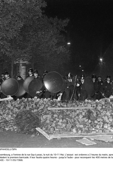 Des CRS donnant l'assaut, au niveau du jardin du Luxembourg, à l'entrée de la rue Gay-Lussac, dans la nuit du 10 au 11 mai 1968 à Paris. (SIPAHIOGLU / SIPA)