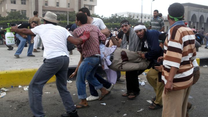 Des membres des Fr&egrave;res musulmans portent un manifestant bless&eacute; lors de heurts avec la police, le 27 juillet 2013 &agrave; l'est du Caire (Egypte). (ASMAA WAGUIH / REUTERS )