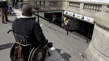 Un homme en fauteuil roulant en haut des escaliers d'une station de métro, le 13 mai 2014 à Paris. (ALAIN JOCARD / AFP)