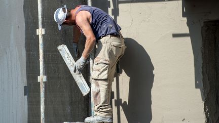 Un maçon sur un échafaudage. (PHILIPPE HUGUEN / AFP)