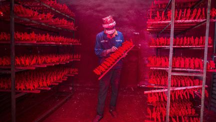Un ouvrier travaille dans une usine de fabrication de d&eacute;corations de No&euml;l &agrave; Yiwu (Chine), le 4 d&eacute;cembre 2014. ( CHINA DAILY / REUTERS)