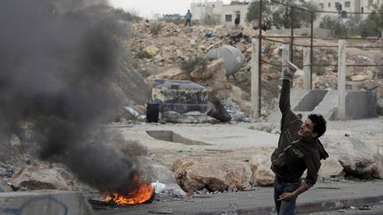 Un Palestinien jette une pierre sur les forces isra&eacute;liennes au checkpoint de Qalandia, dans la bande de Gaza, le 19 novembre 2012.&nbsp; (AHMAD GHARABLI / AFP)