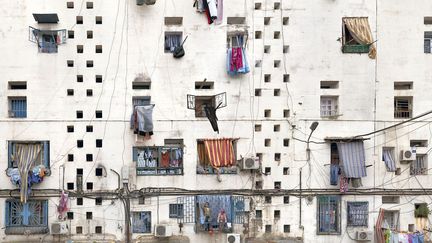 Stéphane Couturier, "Climat de France"
Stéphane Couturier s'est rendu dans le grand ensemble Climat de France construit à Alger dans les années 1950, aujourd'hui une cité surpeuplée. Il expose de grands tirages de vues resserrées des façades où linge, paraboles ou climatiseurs cassent les lignes géométriques de l'architecture. Il a aussi fait des portraits filmés frontaux quasi immobiles de ses habitants, hommes et petits garçons qui tournent en boucle. A la MEP. "Climat de France", Alger, 2014
 (© Stéphane Couturier)