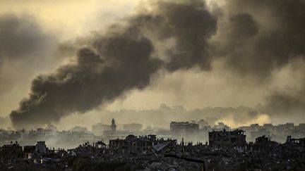 Smoke rising above buildings in the Gaza Strip, November 22, 2023. (JOHN MACDOUGALL / AFP)