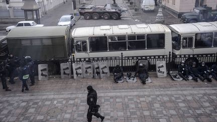 Des policiers se reposent derri&egrave;re des bus devant le Parlement &agrave; Kiev (Ukraine), le 20 f&eacute;vrier 2014. (REUTERS)