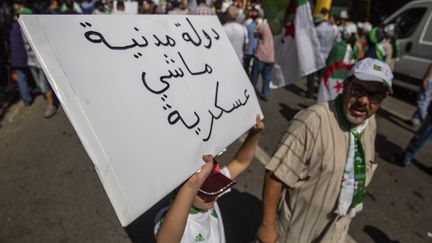 Un manifestant avec une pancarte "Etat civil et non militaire", le 30 août 2019 à Alger (SOFIANE BAKOURI / HANS LUCAS)