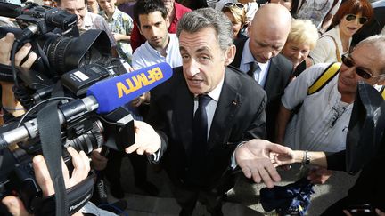 L'ancien pr&eacute;sident de la R&eacute;publique fran&ccedil;aise Nicolas Sarkozy r&eacute;pond aux questions des journalistes &agrave; son arriv&eacute;e &agrave; la mairie de Cannes (Alpes-Maritimes) avant un meeting, le 21 octobre 2014. (VALERY HACHE / AFP)