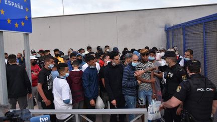 Des migrants attendent de traverser la frontière vers le Maroc dans l'enclave espagnole de Ceuta, le 20 mai 2021.&nbsp; (ANTONIO SEMPERE / AFP)