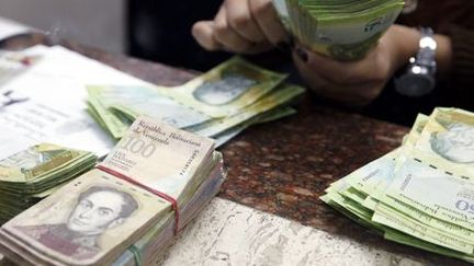 A Caracas, un caissier manipule des bolivars, la monnaie vénézuélienne, le 24 février 2015. (REUTERS - Carlos Garcia Rawlins)