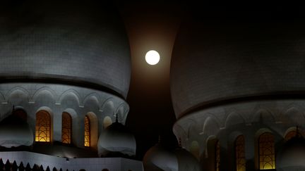 L'éclipse, qui correspond au moment où la Lune plonge dans l'ombre de la Terre, est visible dans tout l'hémisphère est. Mais c'est l'Afrique de l'Est et du Sud, le Moyen-Orient et l'Inde qui sont les mieux lotis pour profiter pleinement du spectacle. Le phénomène est ici observé au-dessus de la grande mosquée d'Abou Dabi (Emirats arabes unis). (CHRISTOPHER PIKE / AFP)