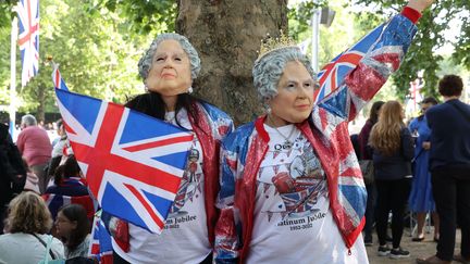 Des spectateurs portant un masque à l'effigie de la reine assistent aux célébrations du jubilé de platine d'Elizabeth II à Londres, le 2 juin 2022. (GEORGE CRACKNELL WRIGHT/ LNP / SHUT/ SIPA)