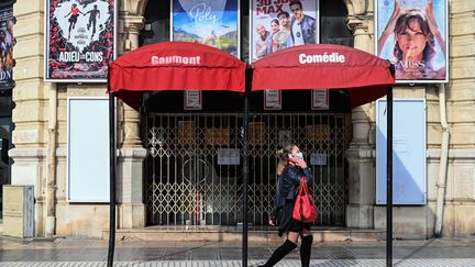 Une femme passe devant un cinéma fermé à Montpellier, dans le sud de la France, le 13 novembre 2020. (PASCAL GUYOT / AFP)