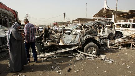 Des Irakiens sur la sc&egrave;ne d'un attentat pr&egrave;s d'un march&eacute; de Bagdad (Irak), le 7 mars 2014. (ALI AL-SAADI / AFP)