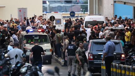 Des ambulances entourées par la foule, autour d'un hôpital de Beyrouth, le 17 septembre 2024. (ANWAR AMRO / AFP)