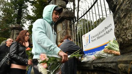 Des fleurs sont déposées devant le lycée Saint-Thomas-d'Aquin, le 23 février 2023, où une professeure a été tuée par un élève à Saint-Jean-de-Luz (Pyrénées-Atlantique). (GAIZKA IROZ / AFP)